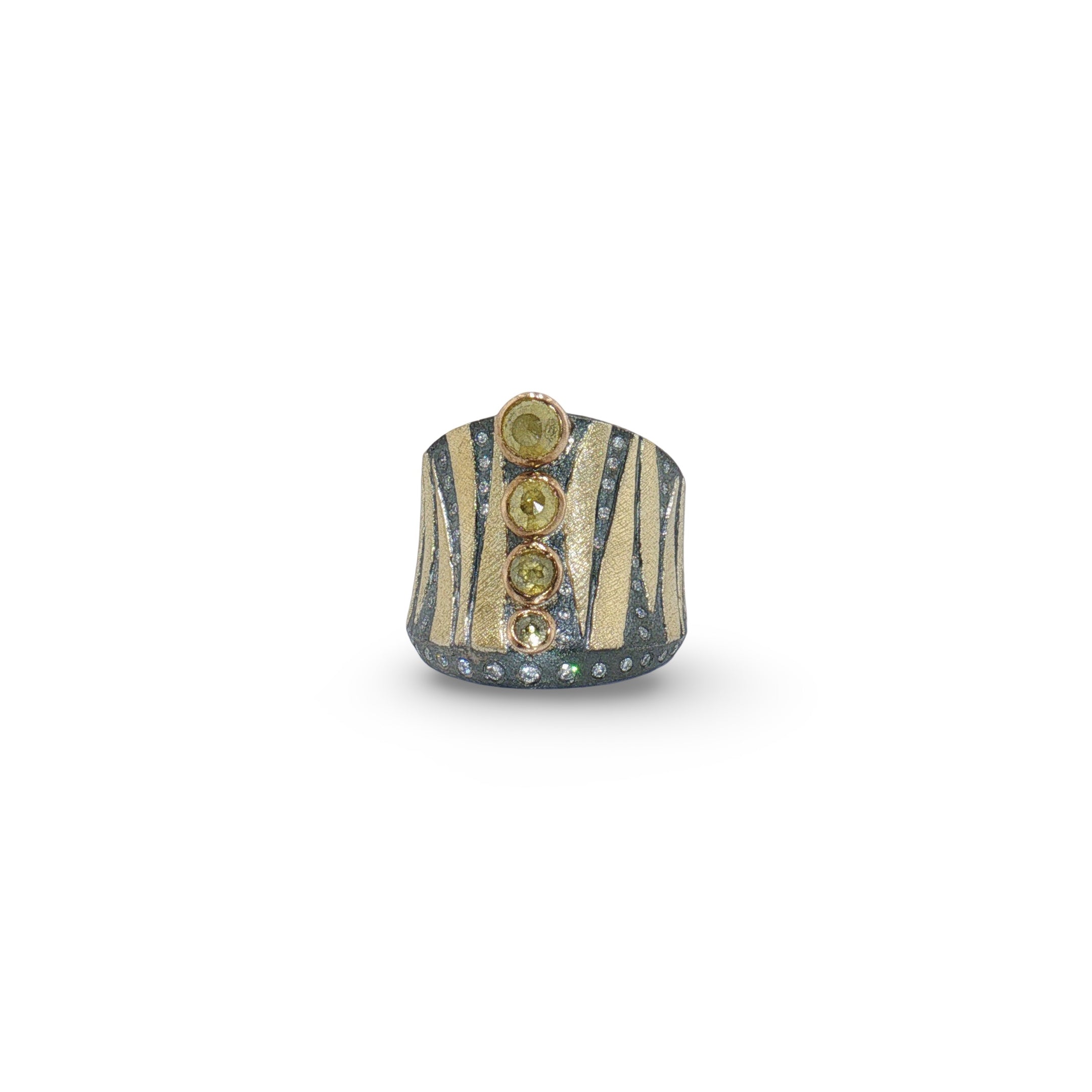 A wide band ring featuring a textured dark gray and gold striped pattern, adorned with three vertical rows of round green gemstones and small clear rhinestones along the lower edge, set against a plain white background.
