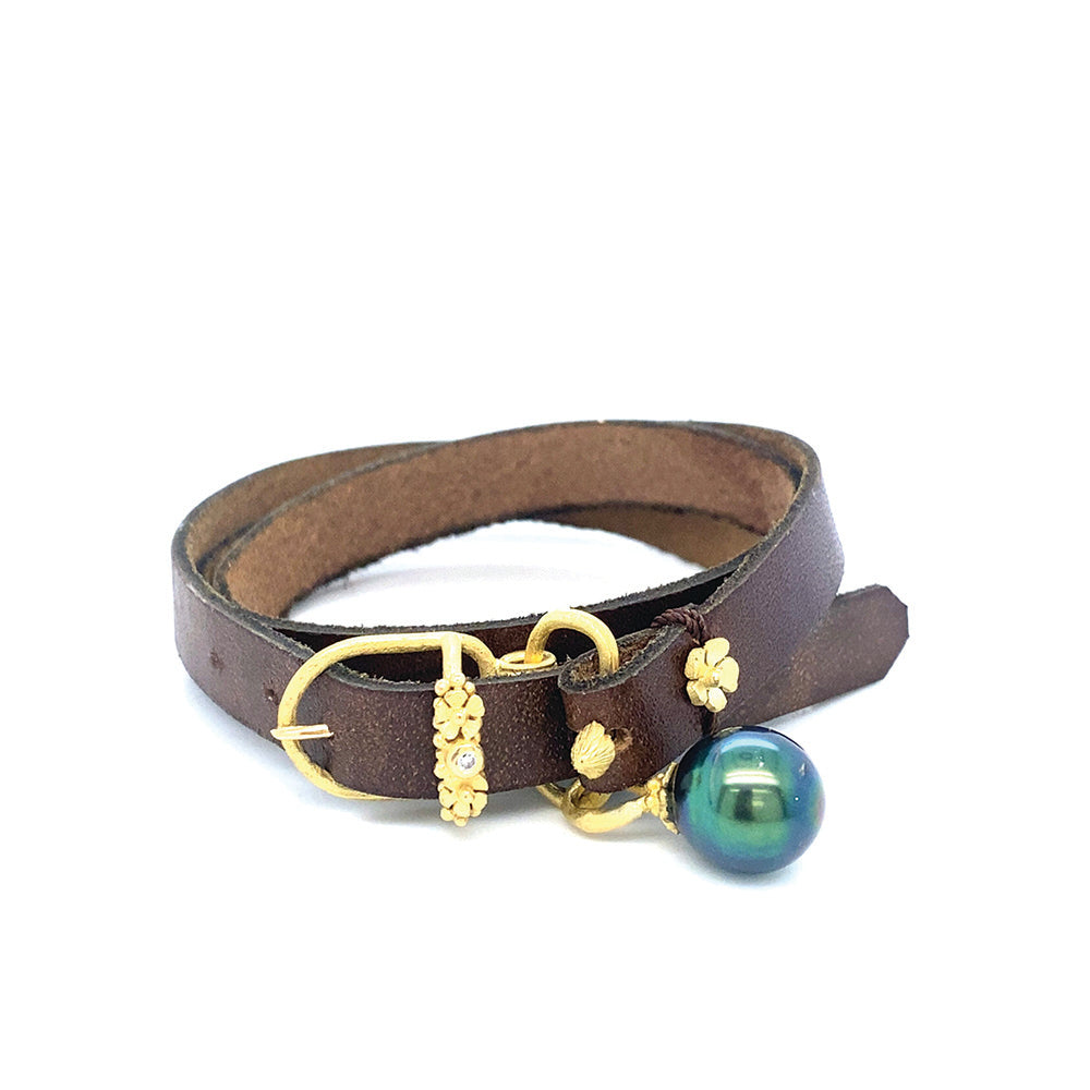 Leather wrap bracelet with adjustable 18k yellow gold buckle, floral, mushroom and diamond accents, 0.03ct, and a Tahitian pearl.