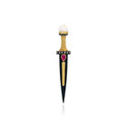 A decorative dagger-shaped pin or pendant with a black blade, gold-toned guard and center stripe, a small red heart-shaped gemstone, and a white top section, shown on a plain white background.