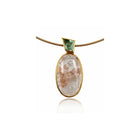 oval quartz pendant with quartz and iron inclusions with green tourmalinee
