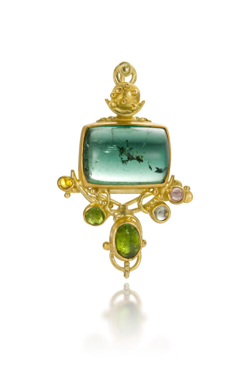 "Dreaming in Green" pendant with a rectangular, light indicolite blue-green tourmaline cabochon with a feather inclusion, 11.95 cts, and mixed shape and color tourmalines and white sapphire cabochons, set in 22k and 18k gold. Pendant is 1 5/8" long x 1" wide (41 x 25mm).
