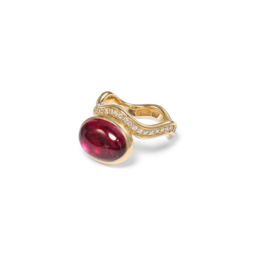 Aurora ring in 18k yellow gold with an oval rubellite cabochon offset on a wavy pavé-set diamond band with vs white diamonds, 0.45 cttw. Ring is 5/8" wide (15mm) and is a size 7.25.