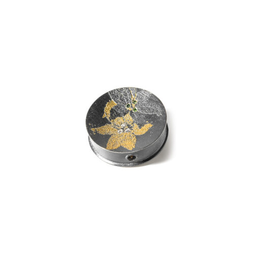 Round, double-sided "Lily" Vario clasp in oxidized sterling silver, 24k yellow gold, white (G) vs diamonds, 0.06cttw, green diamonds, 0.03cttw, and reddish-brown diamonds, 0.03cttw. Clasp is 1" in diameter.