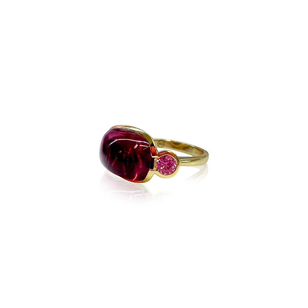 18k yellow gold crownwork, three-stone scallop ring with bezel-set pink tourmaline center stone, 8.35 cts, and pink sapphire side stones, 0.63 cttw. Ring is a size 6.5 and is 3/4" x 1/2".