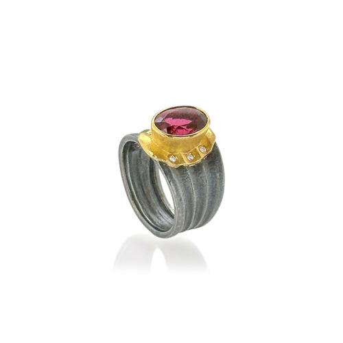 Pink oval rubellite tourmaline ring, set in oxidized sterling silver and 18k and 22k yellow gold with six diamonds, 0.6 cttw. Tourmaline is 9 x 11mm and ring is a size 7.