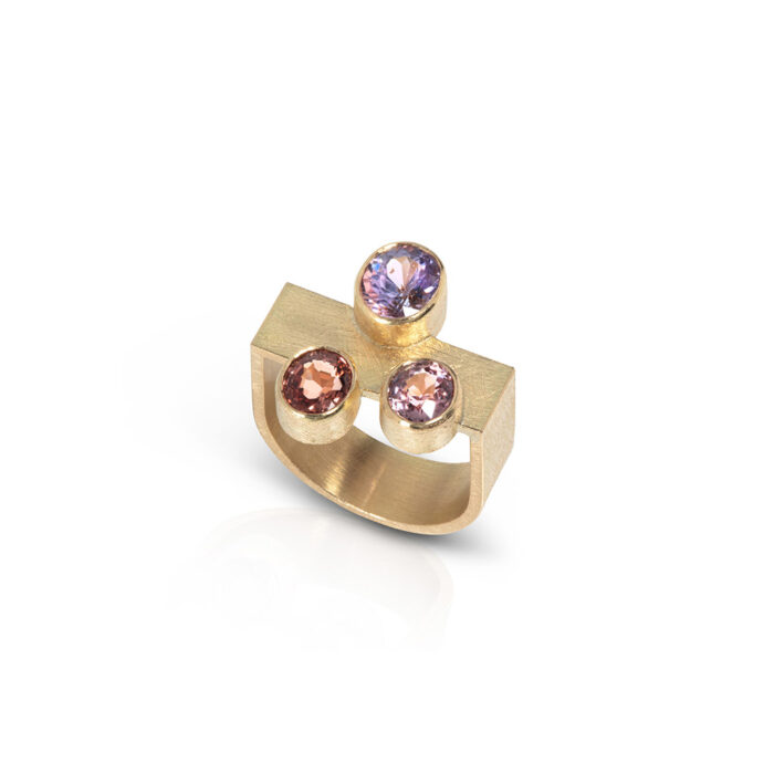 18k yellow gold U-shaped ring with three oval spinels in lilac (1.13ct, 6.5x6.5mm), light pink (0.61 ct, 5.4 x 4.9mm), and reddish pink (0.75 ct, 5.7 x 5mm). Ring is a size 7.25.