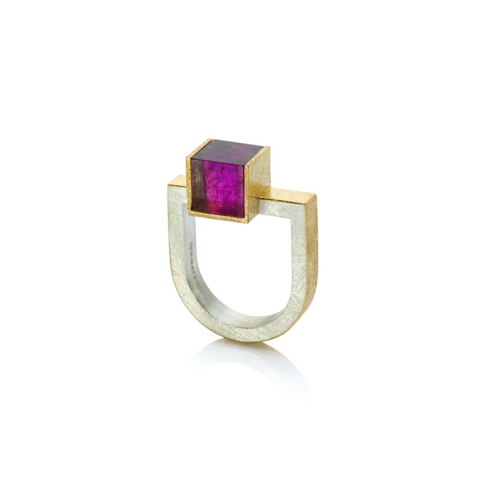 18ct Yellow Gold and Silver D Ring with Cube Pink Tourmaline (8mm) 18k yellow gold and sterling silver U-shaped ring with an offset bi-color pink tourmaline cube, 8mm. Viewed from the top, cube is pink, viewed from the side, hints of watermelon tourmaline appear. Ring is a size 8 and can be stacked with the offset bi-color green and peach tourmaline ring and U-shaped diamond bar ring.