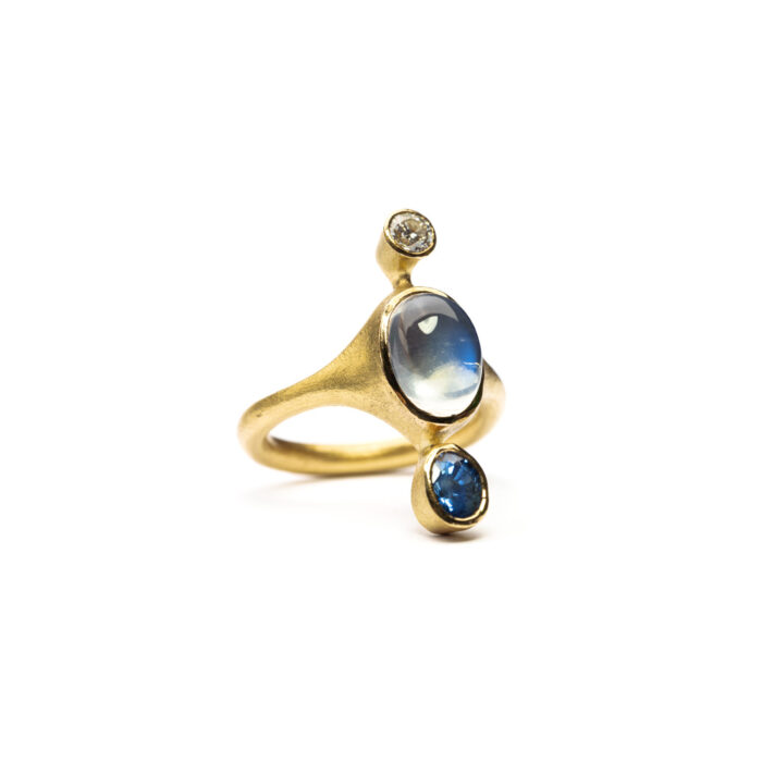 237.117 Ring in 18K + 22K gold, with blue flash moonstone, 3.71 cts, unheated blue sapphire, 0.95 ct, white (G) brilliant cut diamond vsi 0.25 cts. Ring is size 7 and 1 1/8" long (27mm).