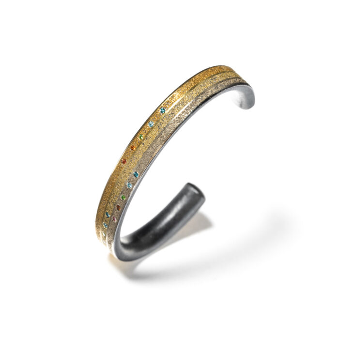 Oxidized sterling silver cuff with multi-color gold alloys, 19k & 24k, fancy colored diamonds, 0.15cttw, size small. Cuff is 5/16" wide (8mm) and 5.75" interior dimension.