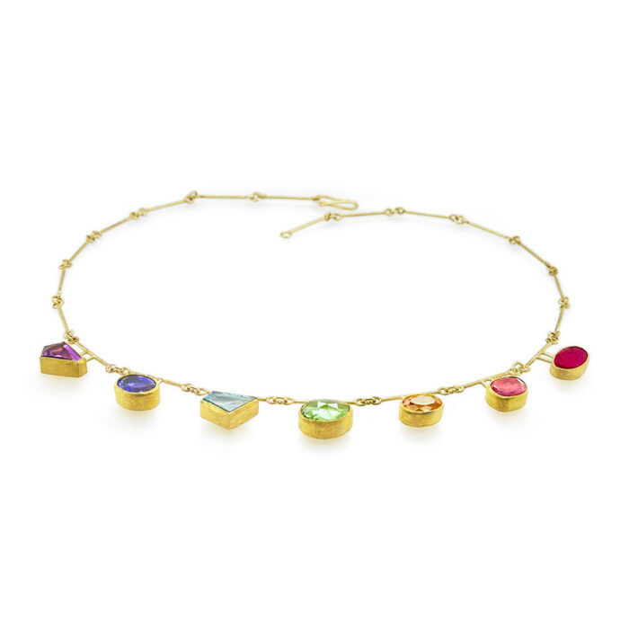 Mixed cut precious gemstones in rainbow formation (amethyst, Tanzanite, aquamarine, tourmaline, citrine, and ruby) totaling 17 cttw, set in 22k and 18k yellow gold. Necklace is 18" long with a S-hook clasp.